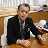 スーツを着てほほ笑む短髪の男性の写真