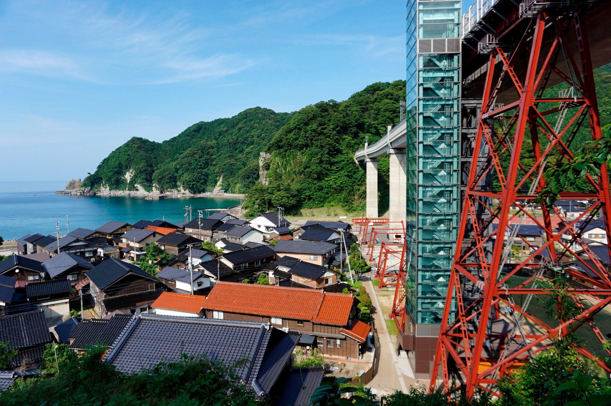 民家の横にある鉄橋の写真
