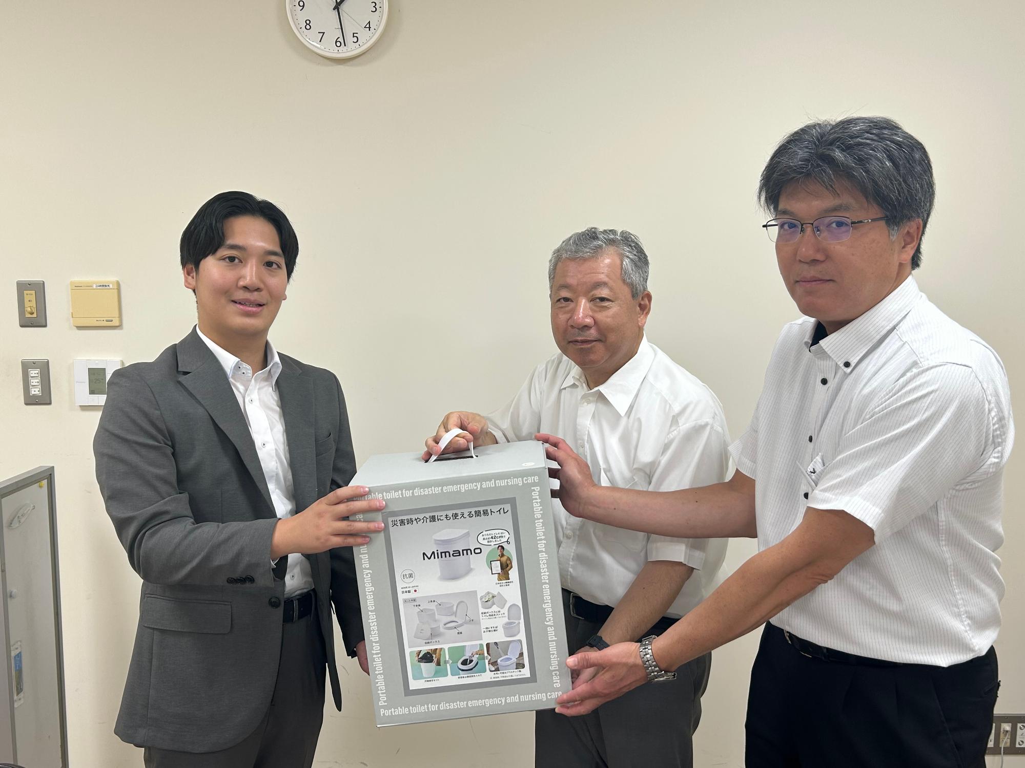 株式会社伊勢藤様から「簡易トイレMimamo」を受け取る町防災安全課職員