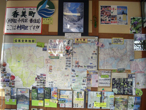 観光案内所内に掲示された香美町周辺の地図や観光情報をまとめた壁面を写した写真