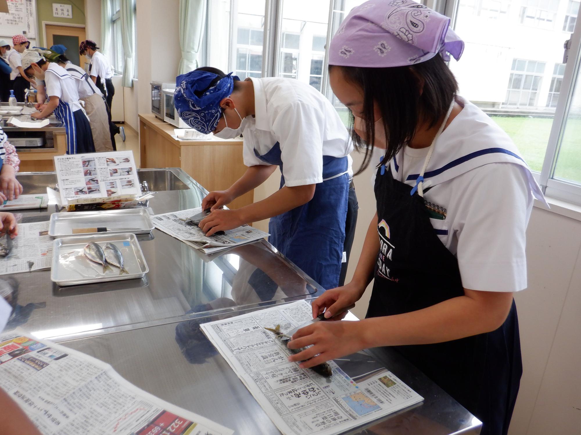 生徒たちが魚をおろしている様子の写真