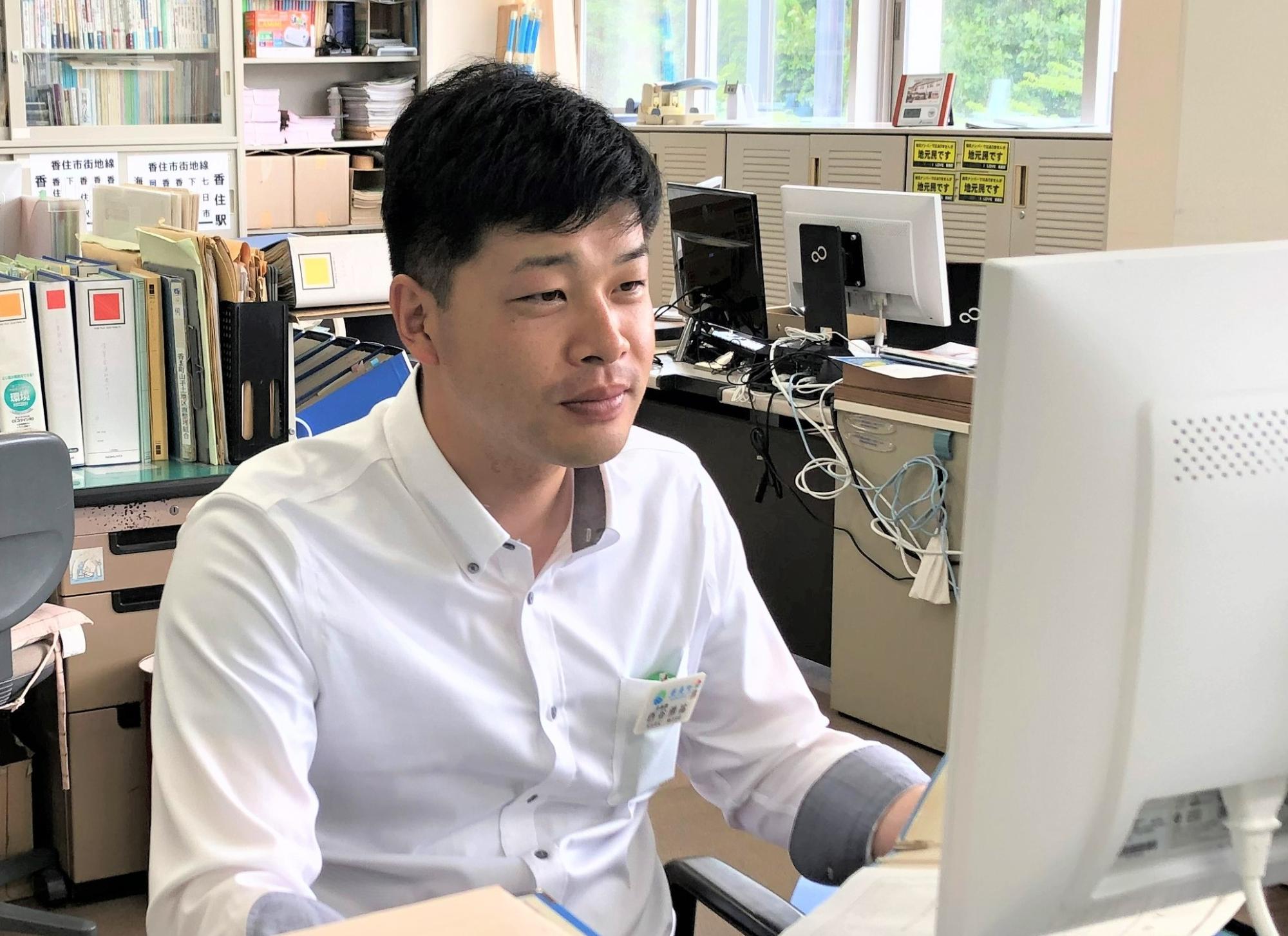 白い服を着てパソコンに向かっている町役場職員の写真
