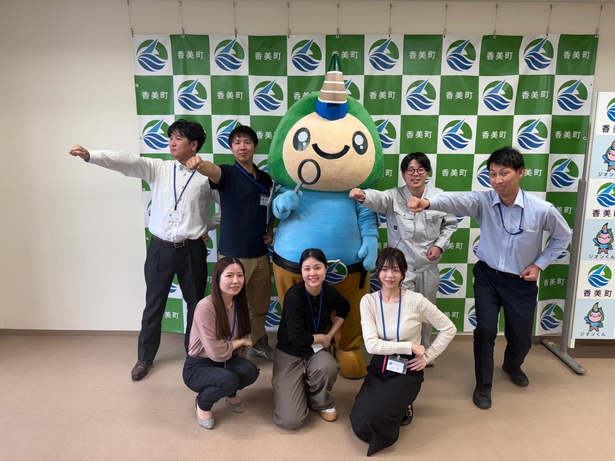 拳を突き出したポーズの男性陣4人と腰に手を当てたポーズの女性陣3人、中央にジオンくんがいる香美町職員採用プロジェクトチームの集合写真