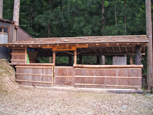 屋根と下半分のみに壁がある横長の建物の写真