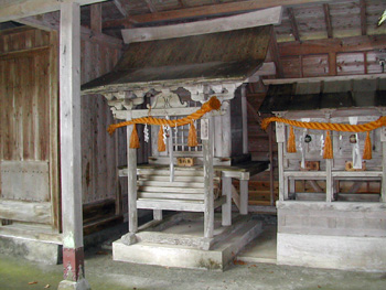 赤いしめ縄がついた2つの小さな神社の写真