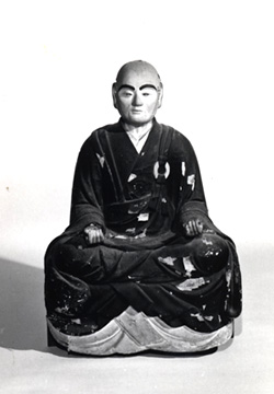 和装で座っている男性像の白黒写真