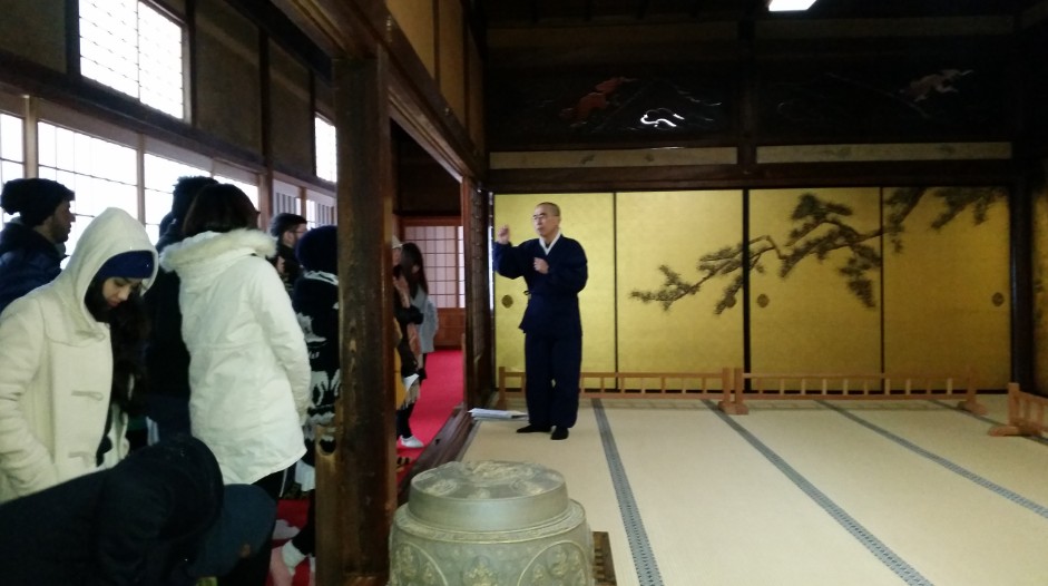 住職が観光客に襖絵の説明をしている写真