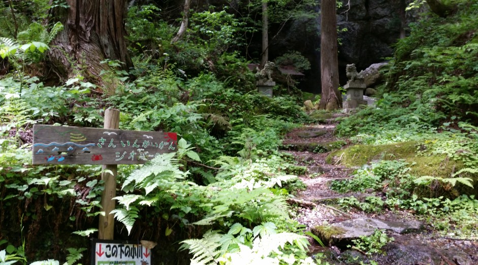 「さんいんかいがん」と書かれた看板の先の森へ続く石階段の写真