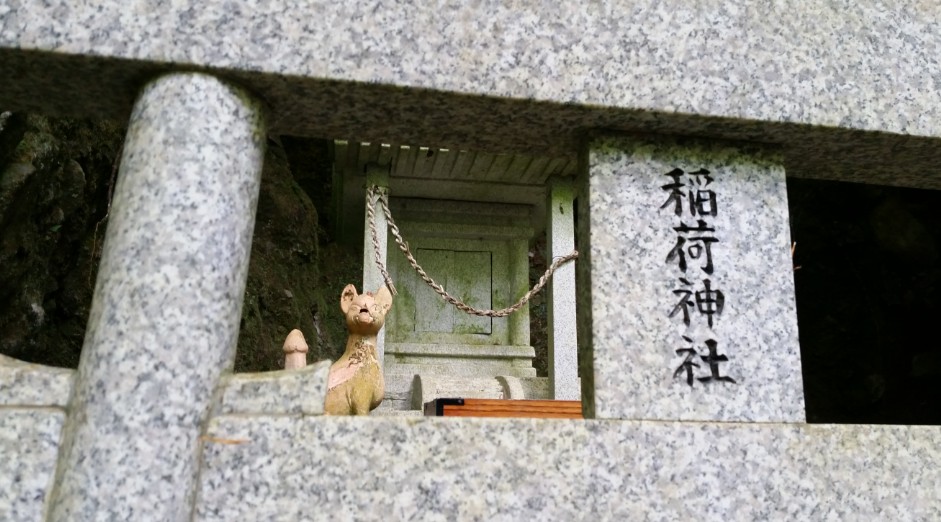 稲荷神社と書かれた祠にキツネの石像が置かれている写真