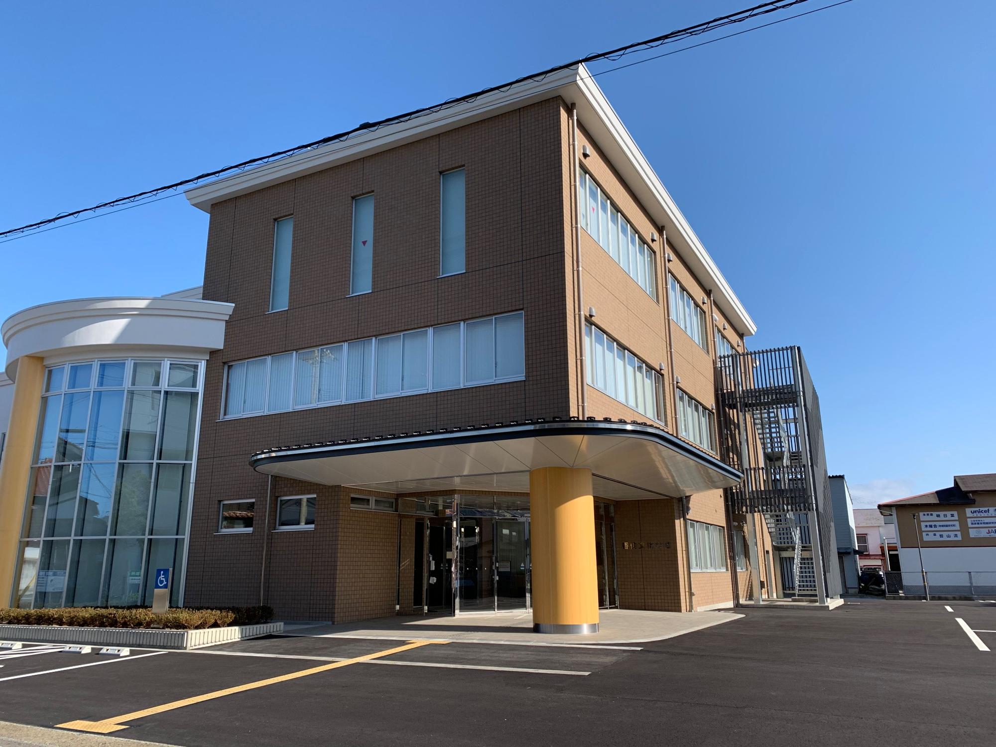 駐車場付きの赤茶色の建物入り口の写真