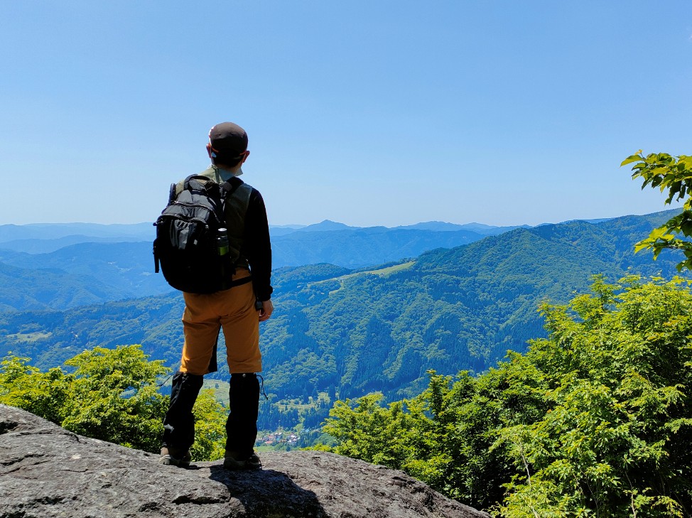 山の上から麓を見下ろしている人の写真