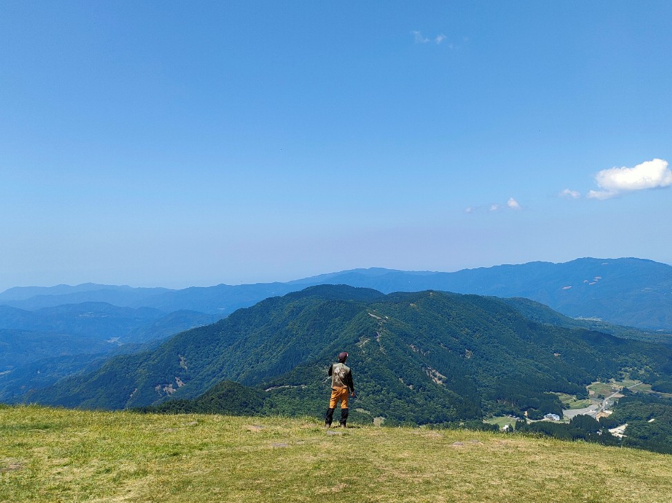 高原から他の山を眺めている人の写真