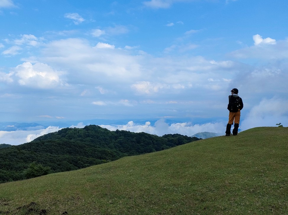 高原から他の山を見下ろしている人の写真