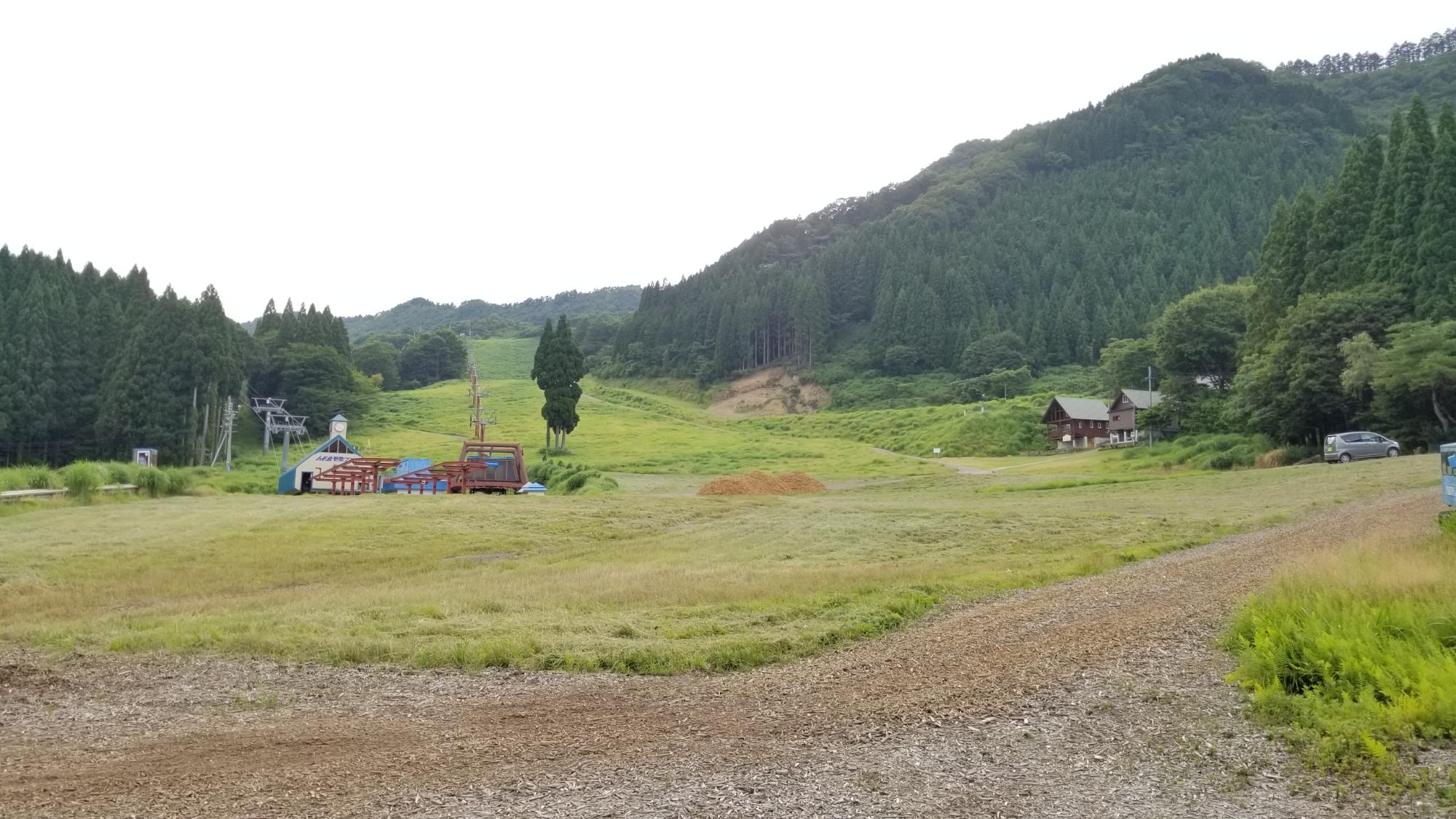 山中にある草原のそばに砂利道がある写真