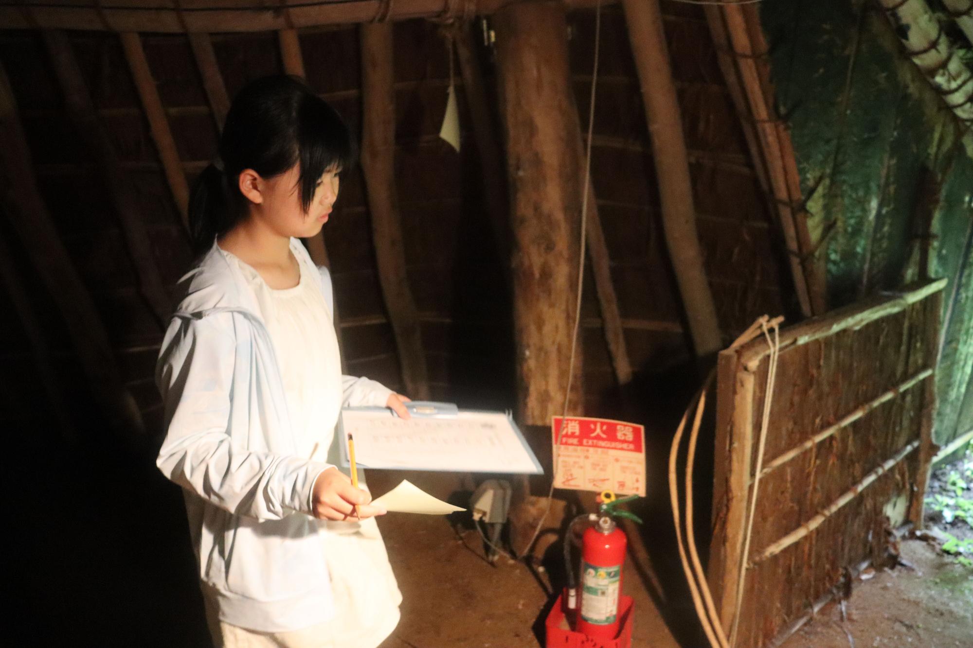 バインダーと紙を手にもって歩く女の子の写真