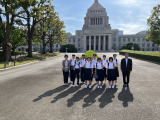 国会議事堂の中庭に整列して集合写真を取っている先生と生徒たちの写真