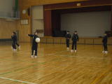 体育館でジャージ姿の生徒たちがボール運動をしている写真