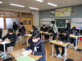 教室で生徒たちがプリントに記入しながら学習している写真