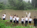 少し空気が曇っている山間の田んぼの前で中学生たちが並んでいる写真