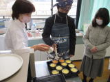 家庭科室で先生の指導を受けながら型に流し込んだ生地を焼いている写真