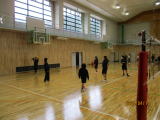 体育館でジャージ姿の生徒たちが部活動をしている様子の写真