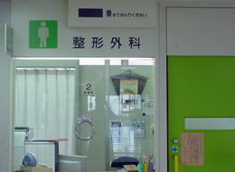 整形外科の受付窓口と診察室入口が並ぶ病院内の写真