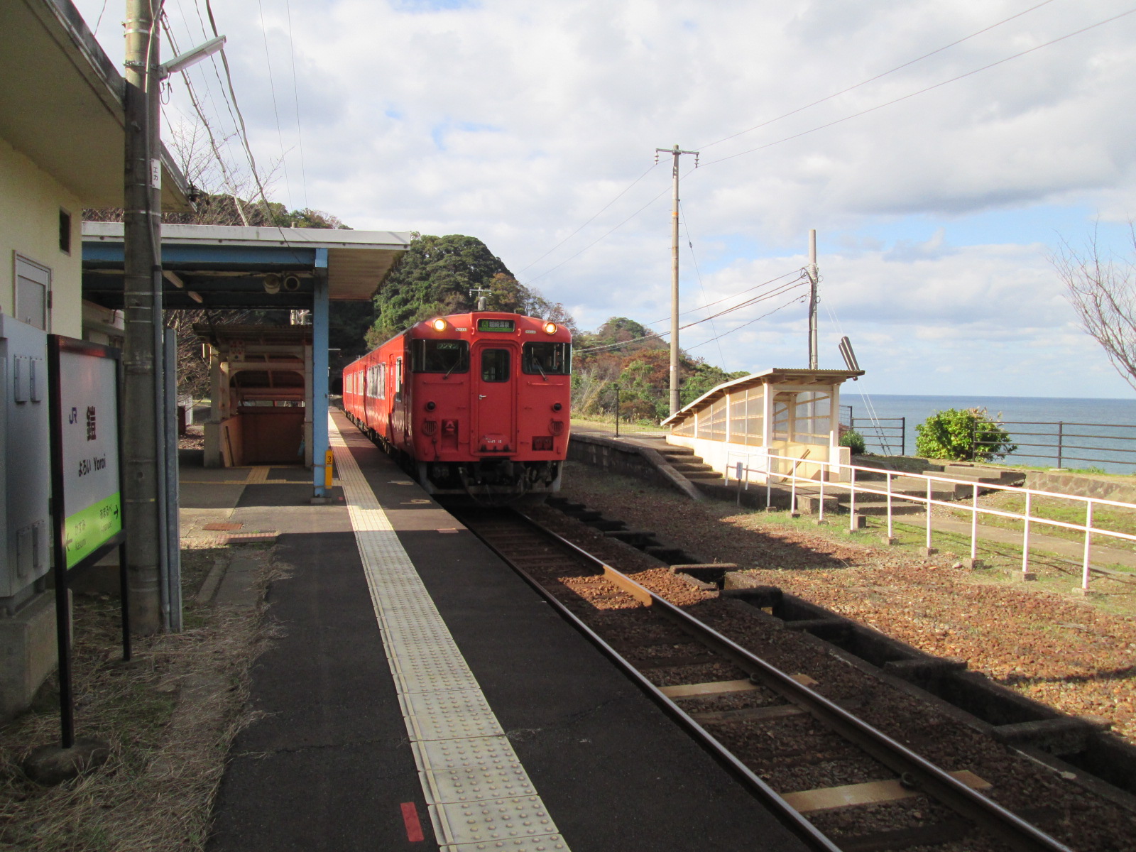 鎧駅に停まっている赤い電車の写真