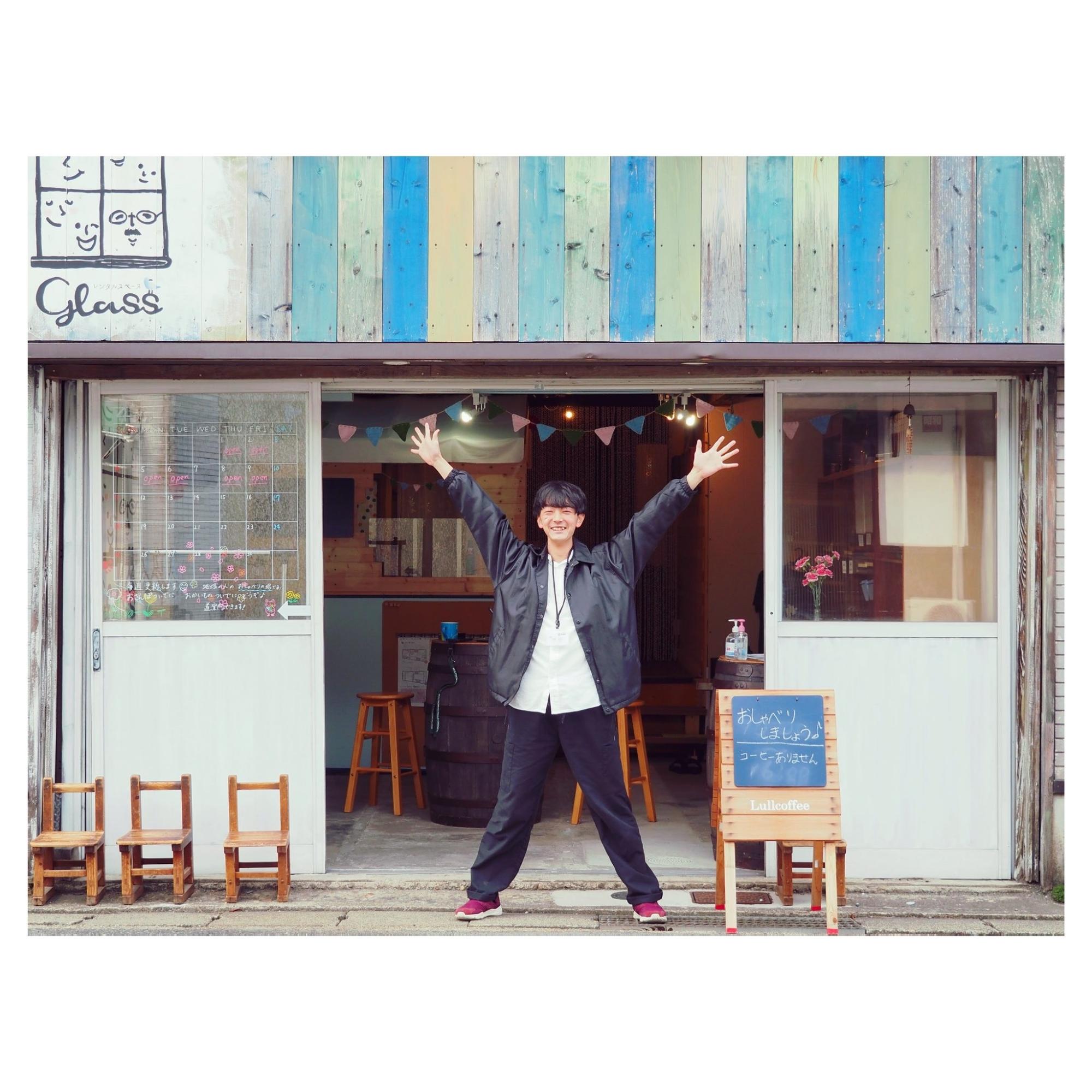 レンタルスペースglassの前で両手をあげている青年の写真