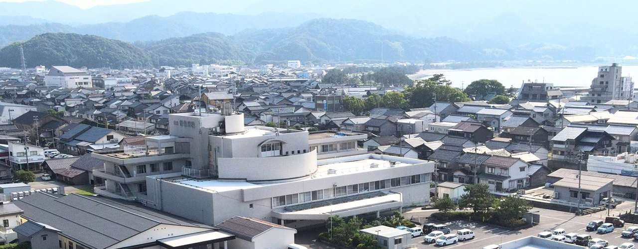 香住病院の遠景 手前に香住病院があり奥には住宅地と海、山が広がっている