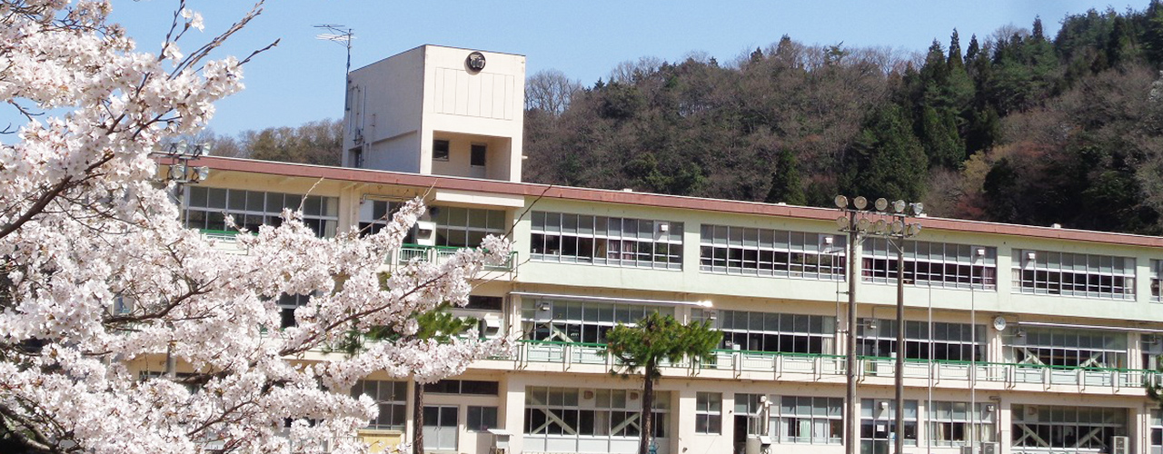 兎塚小学校舎の外観写真 手前には桜が咲いている