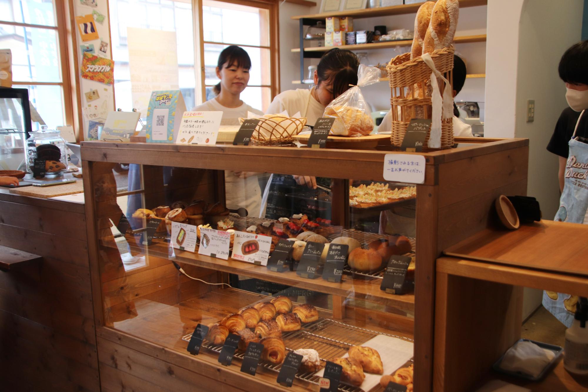 ケーキを店頭に並べる中学生の写真