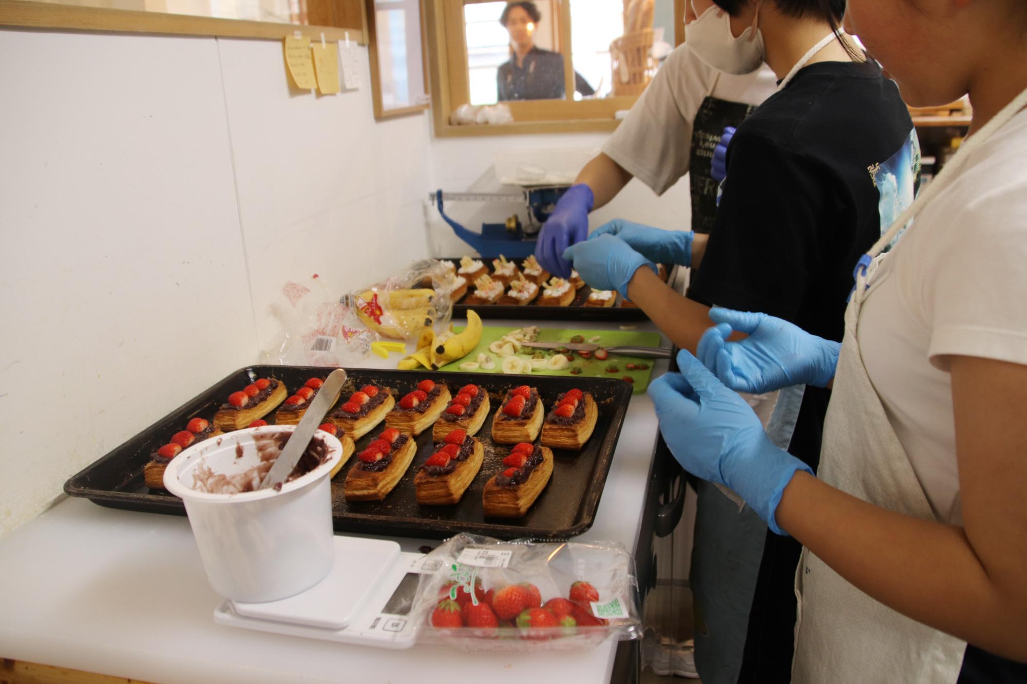 自分たちで考えたケーキを作っている中学生の写真