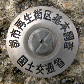 都市再生街区基本調査と書かれた銀色プラスチック製の金属鋲の写真