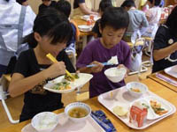 室内で児童たちが給食を食べている様子の写真