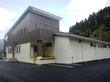 雲がある空の下白と薄茶色を基調とした建物の写真