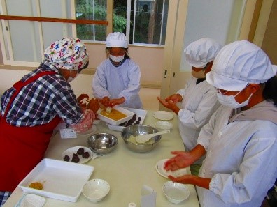 室内で児童たちがおはぎ作りを行っている様子の写真