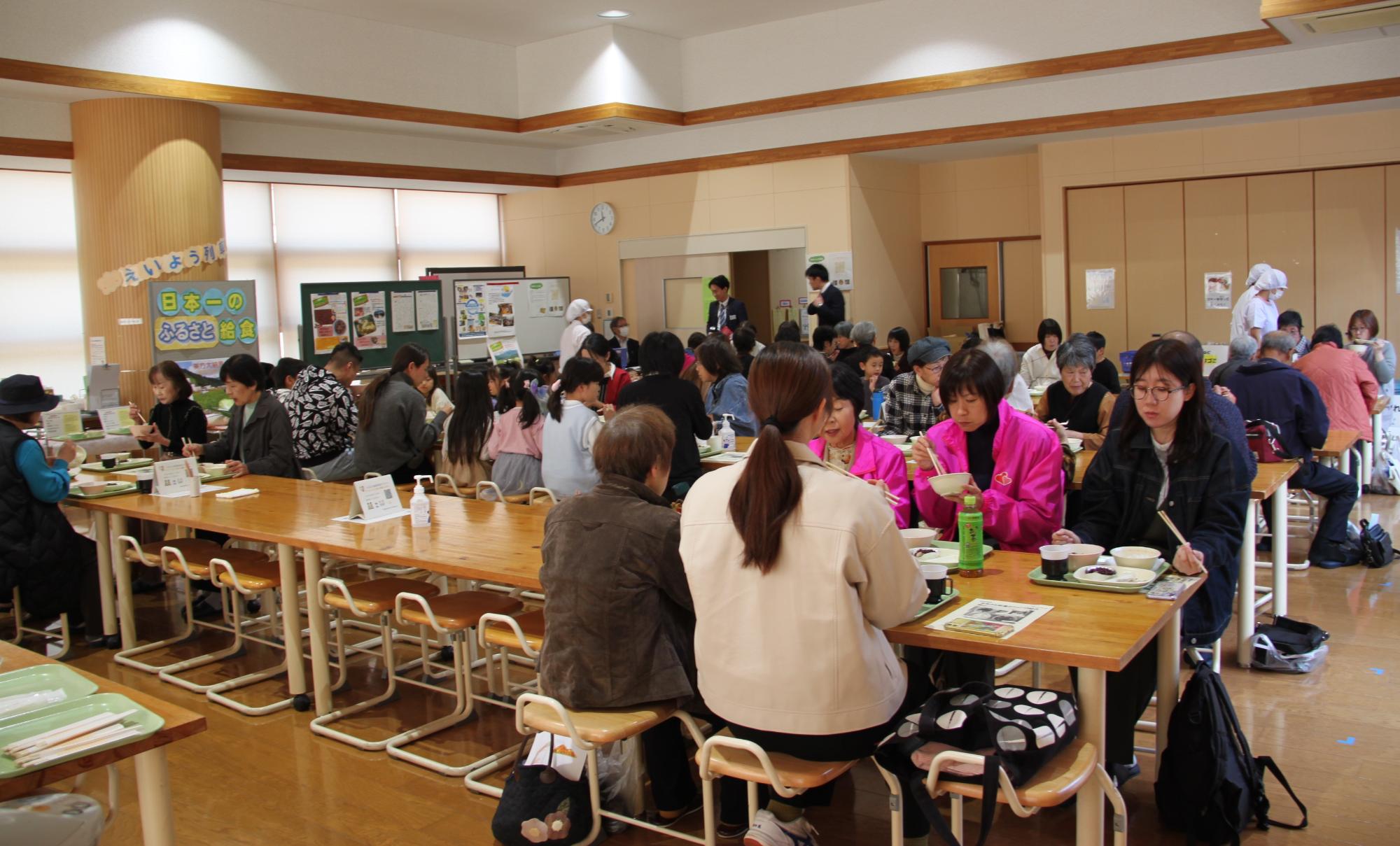 室内で大人たちが食事を取っている様子の写真