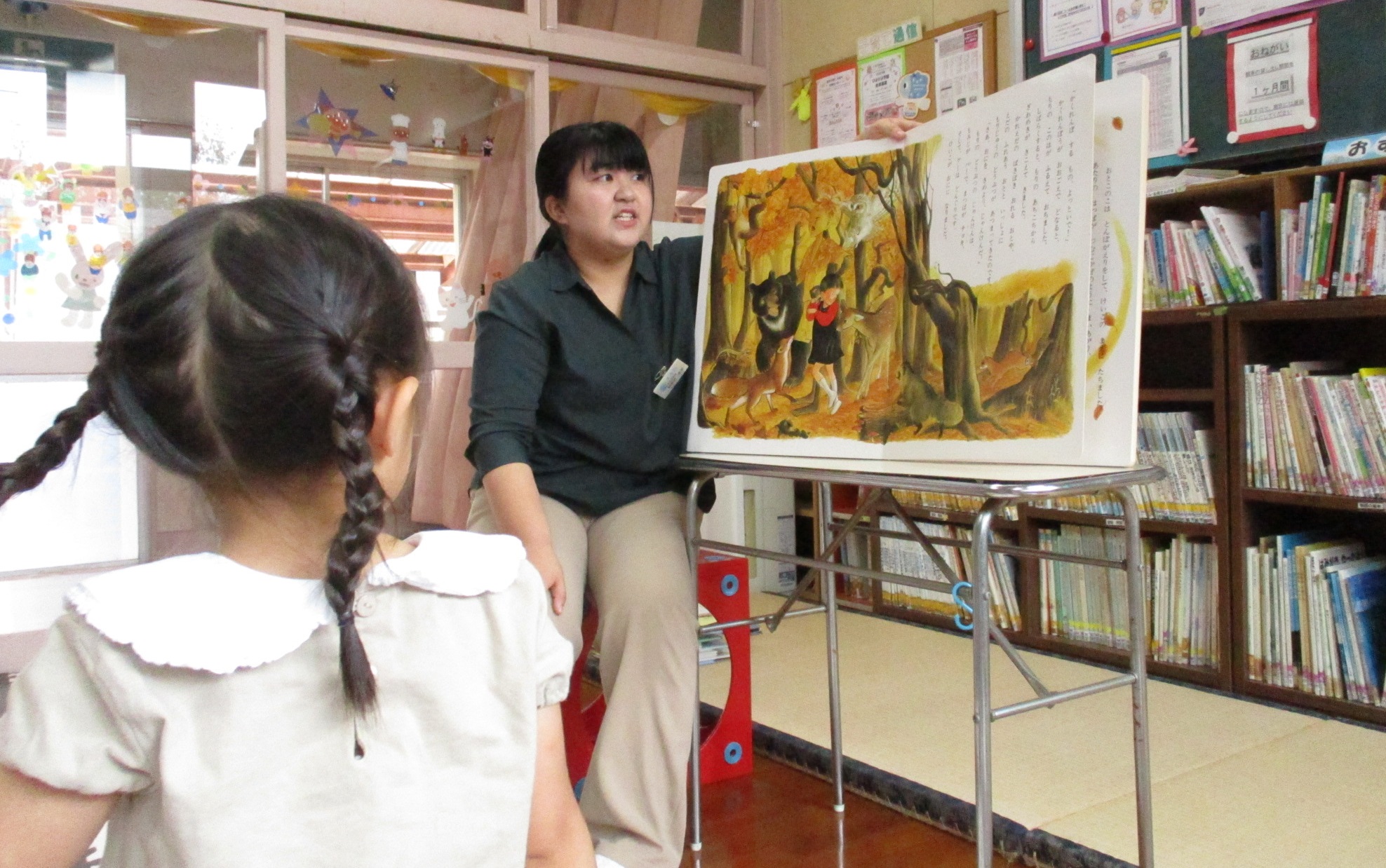 教室で大人が児童に絵本を読んでいる様子の写真