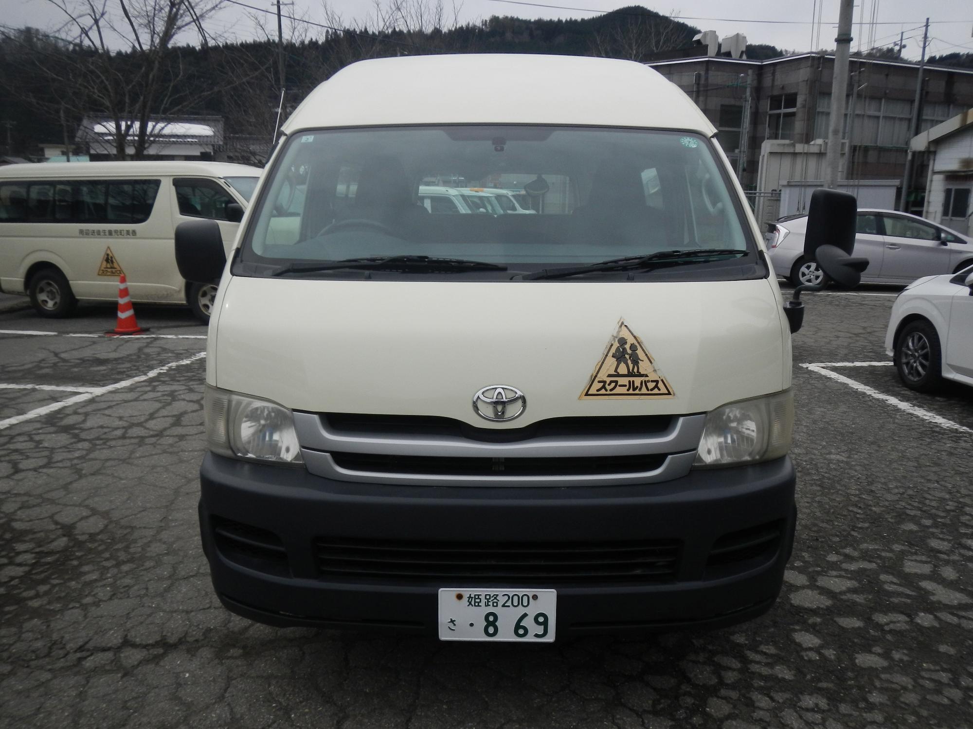正面から見たクリーム色のトヨタハイエースコミューターの写真