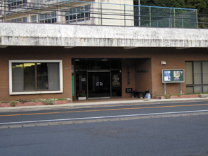 茶色い壁で一階建ての建物の玄関の写真