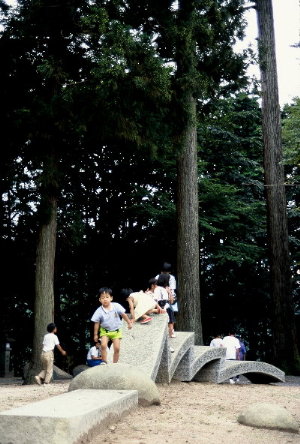 石彫遊具に乗って遊ぶ子供達の写真