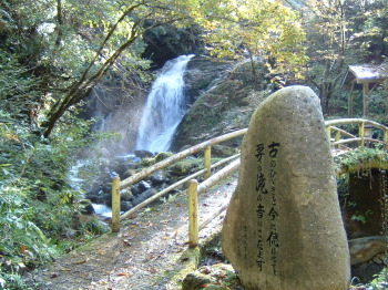 滝と橋の手前に置かれた石碑の写真