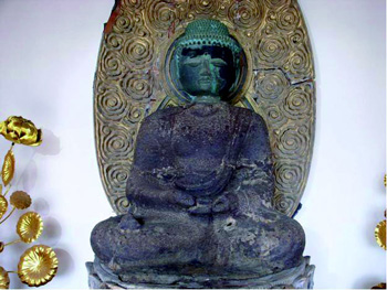 頭部が緑がかっている大仏の写真