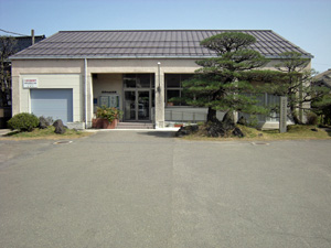 広い敷地の奥に建っている平屋の建物の写真