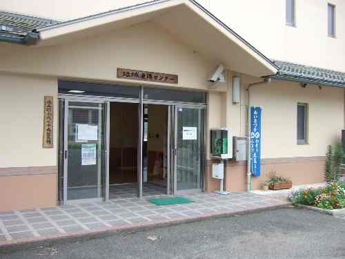 入口に公衆電話が設置されたクリーム色の建物の玄関の写真