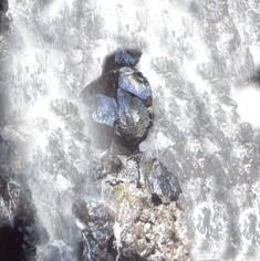 激しく流れる水の中から飛び出ている岩の写真