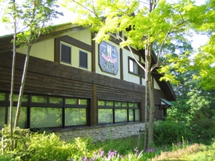 林の中に建っている三角屋根の建物の写真