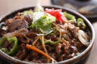 紅ショウガやネギが添えられた肉サラダの写真