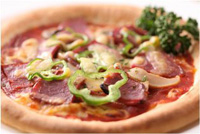 肉やピーマンが乗っているピザの写真
