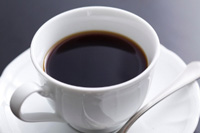 白いカップに黒色の飲み物が淹れられている写真